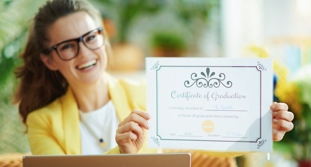 A relationship coach holding a certificate.